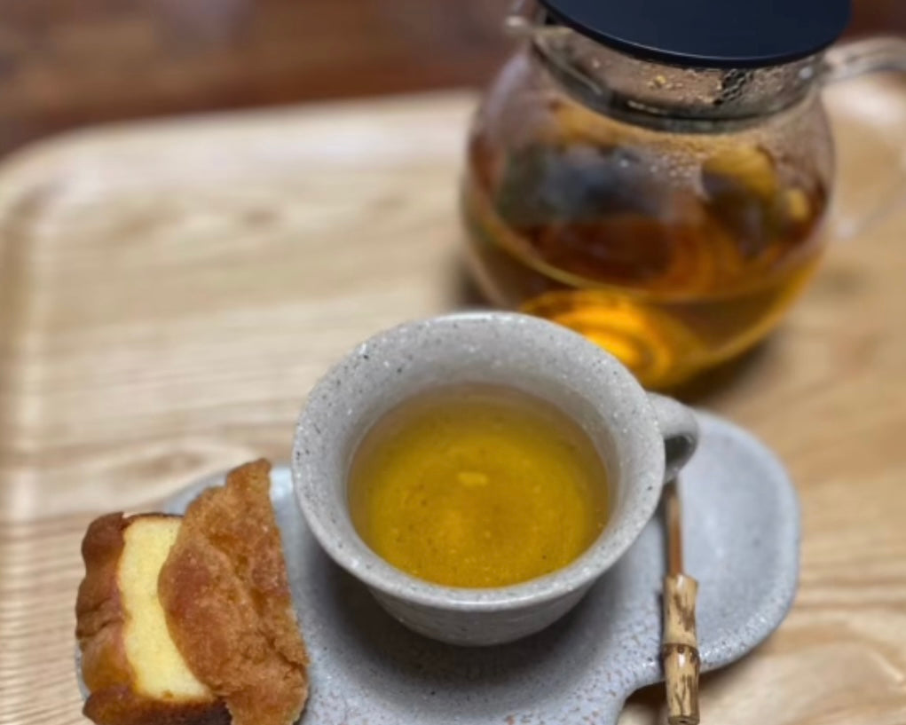 カップに入れたコーヒーの葉のお茶とサーターアンダーギー